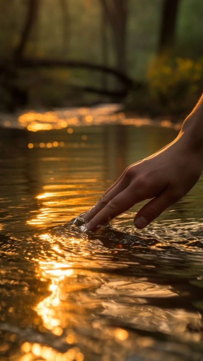 Ritual espiritual, mano tocando agua dorada